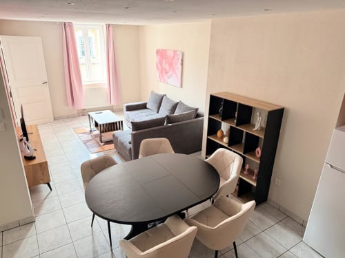 Élégante salle à manger moderne de l'Hôtel Saint Christophe Belfort avec table noire, chaises beiges et rangements