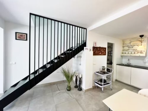 Moderno apartamento en Fuengirola con escalera negra, cocina y diseño interior contemporáneo
