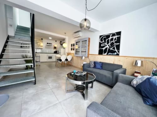 Moderno apartamento en Fuengirola con salón abierto, sofá gris, detalles de madera y decoración contemporánea