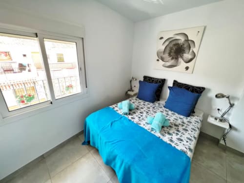 Luminoso dormitorio en encantador apartamento de Fuengirola con toques azules, vistas a la ciudad y comodidades modernas