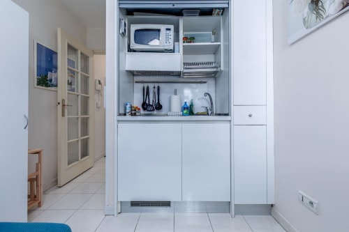 Kitchenette compacte dans l'appartement Admiral à Riviera Home, Roquebrune-Cap Martin, avec micro-ondes, rangements et équipements de cuisson