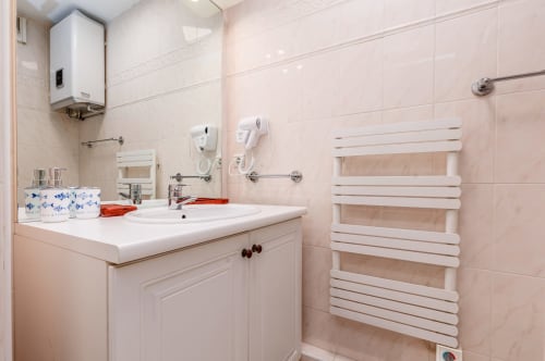 Salle de bain moderne de l'appartement Admiral à Riviera Home, Roquebrune-Cap Martin avec vasque blanche et sèche-serviettes chauffant