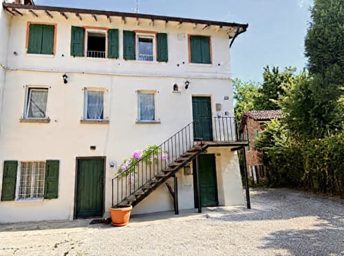 Cottage Il Glicine a Sassuolo, Italia - rustico edificio bianco con persiane verdi e scala in legno