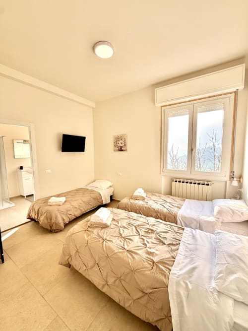 Camera tripla con tre letti presso BBSASSUOLO.IT a Sassuolo, Italia. Alloggio moderno con TV e bagno privato.