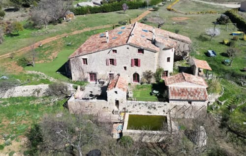 Vue aérienne de la Bastide Saint Michel, charmante maison en pierre à Baudinard sur Verdon, avec toiture en terre cuite et piscine.
