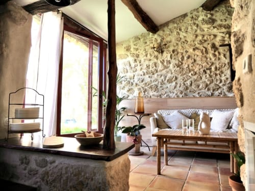 Intérieur rustique de la Bastide Saint Michel avec poutres apparentes, carrelage en terre cuite et mobilier confortable