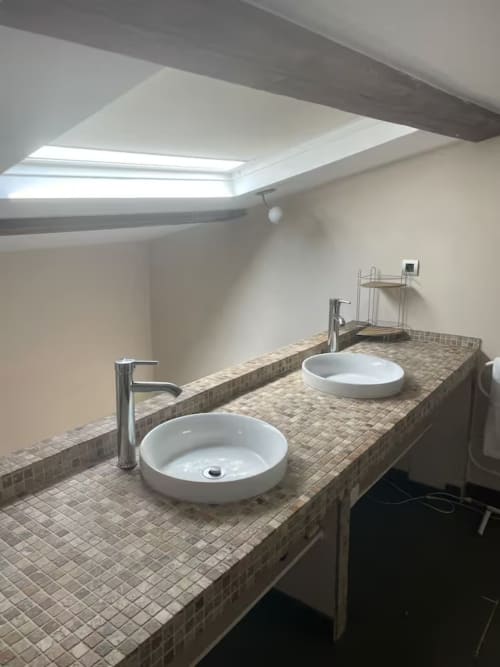 Salle de bains moderne du gîte Le Mosaïque à la Bastide Saint Michel avec deux vasques, puits de lumière et plan de travail carrelé