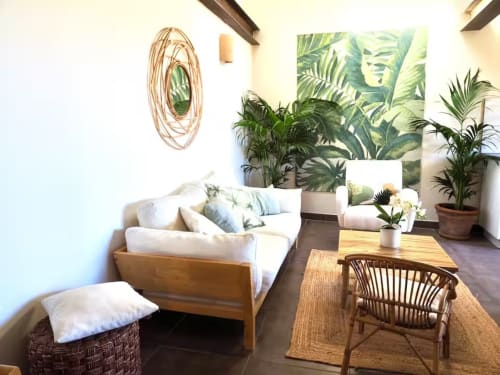 Chambre lumineuse à la Bastide Saint Michel avec mobilier blanc, plantes en pot et décor tropical offrant une vue sur
