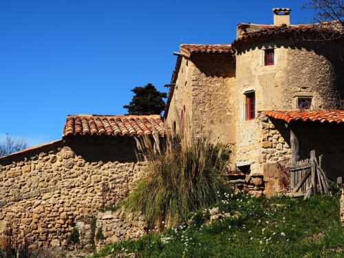 Cottage Bastide Saint Michel aux toits de tuiles terracotta et murs de pierre surplombant le jardin à Baudinard sur Verdon