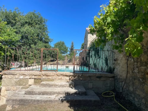 Vue du jardin de la Bastide Saint Michel avec piscine, murs en pierre et verdure à Baudinard sur Verdon