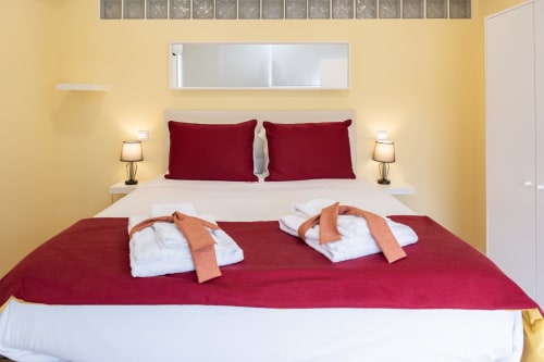 Bright bedroom at RH Charming Apartment Liberdade II in Braga with burgundy pillows, white bedding, and welcoming twin towel