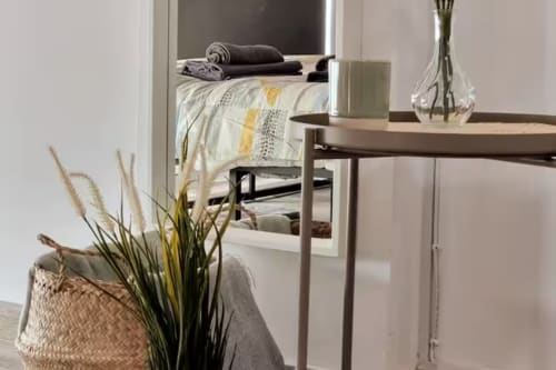 Acogedor estudio moderno en Fuengirola con escritorio, cama, plantas decorativas y mobiliario contemporáneo
