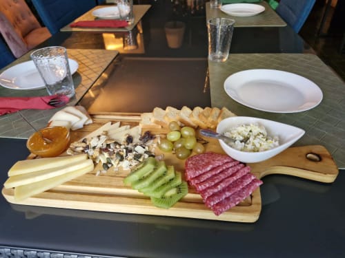 Charcuterie board with cheese, cured meats, kiwi, grapes, bread and dips at Quinta dos Lobos Boutique Hotel in Sintra