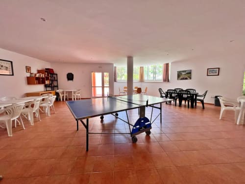 Luminosa sala de ocio con mesa de ping pong, zonas de estar y vistas a Fuengirola