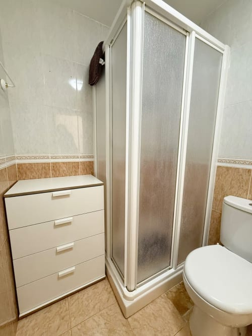 Baño moderno con ducha, inodoro y lavabo en apartamento de playa en Fuengirola de Grupo Inmo House