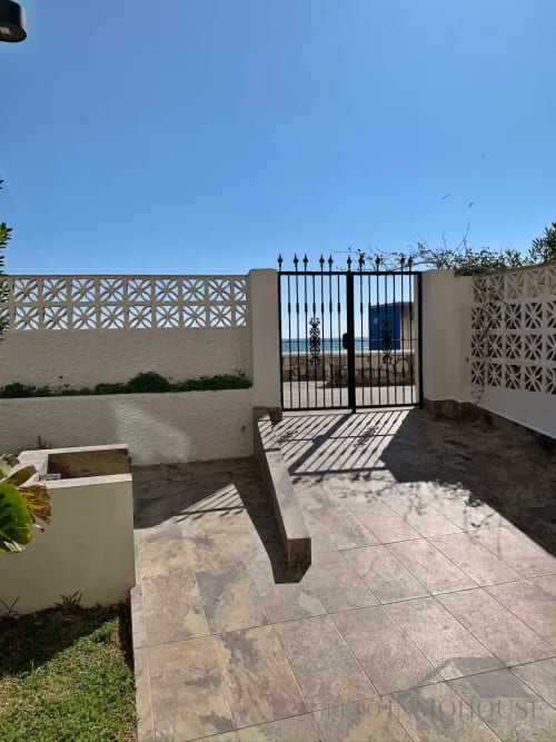 Patio de apartamento frente al mar en Fuengirola con vistas al océano, muros decorativos y puertas de hierro