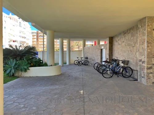 Zona de aparcamiento cubierto en edificio de apartamentos frente al mar en Fuengirola con bicicletas y vistas al mar