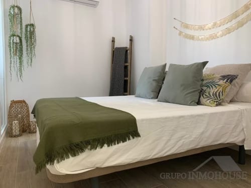 Dormitorio de apartamento frente al mar en Fuengirola con vistas al océano, acentos verde oliva y decoración costera