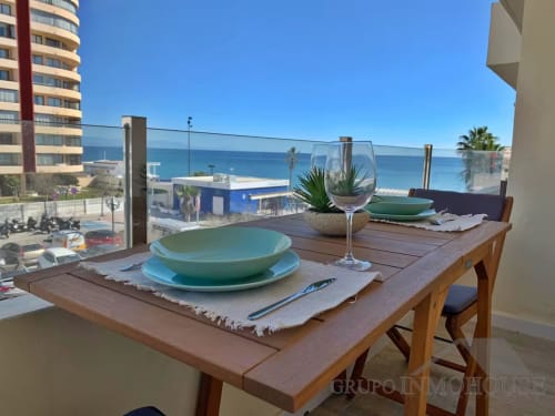 Comedor frente al mar con vistas al mediterráneo en Fuengirola, vajilla turquesa, copa de vino y costa
