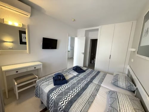 Moderno dormitorio en apartamento frente al mar en Fuengirola con camas gemelas, escritorio, TV y vistas al mar