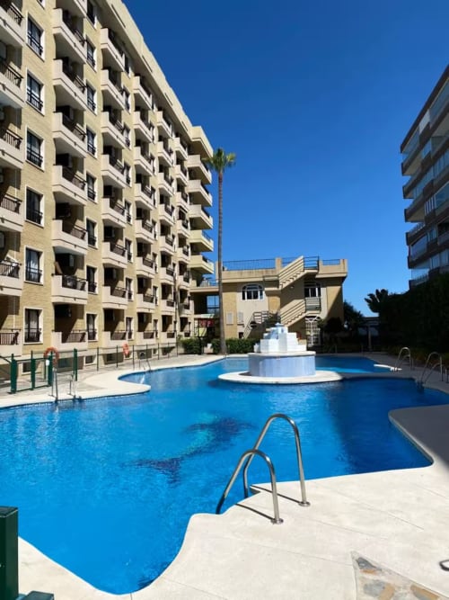 Piscina de apartamento frente al mar con agua azul, trampolines y terraza en Fuengirola