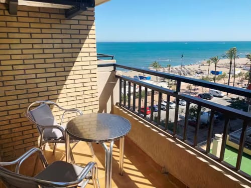 Balcón de apartamento frente al mar en Fuengirola con vistas al agua, mesa y sillas metálicas sobre el Mediterráneo turquesa