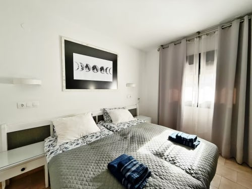 Moderno dormitorio en apartamento de Fuengirola con vistas al mar, muebles blancos y decoración contemporánea