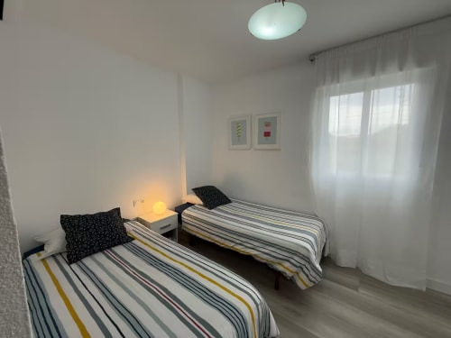 Habitación doble en apartamento frente al mar de Grupo Inmo House, Fuengirola con cama de rayas y vista a la piscina
