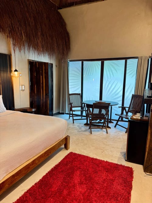 Lujosa habitación de villa en Ala Residencias Chetumal con terraza frente al mar, mobiliario de madera y vistas al océano