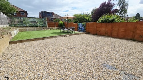 Spacious gravel garden area at Leeds Luxurious Stays villa in Moortown with lawn, seating, and wooden fencing