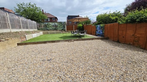 Spacious garden at Leeds Luxurious Stays Borrowdale Brook villa in Moortown, featuring lawn, patio seating, and brown wooden