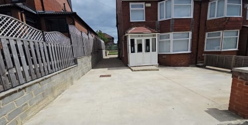 Spacious driveway and entrance to Borrowdale Brook villa at Leeds Luxurious Stays, Moortown, with brick house and white porch