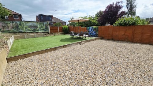 Borrowdale Brook villa garden at Leeds Luxurious Stays featuring gravel patio, lawn, seating area, and wooden fencing