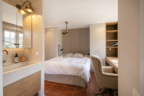 Dormitorio moderno en villa La Pastora, Palafrugell con baño privado, suelos de barro y armarios empotrados
