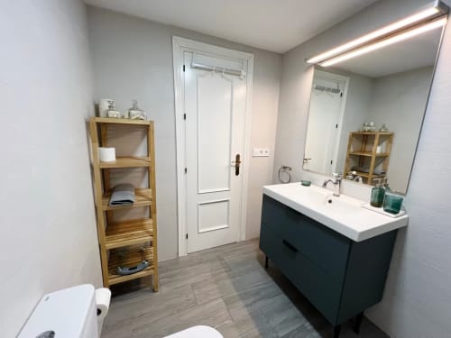 Baño moderno del apartamento frente al mar en Grupo Inmo House, Fuengirola, con tocador de doble lavamanos y vistas al mar