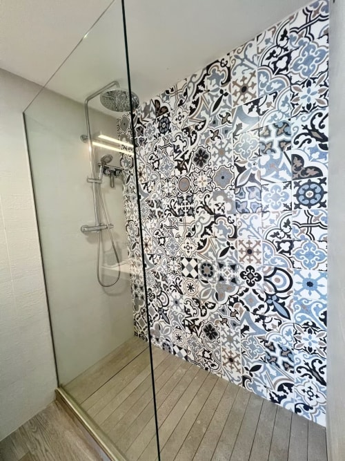 Moderno cuarto de baño junto a la playa con ducha y azulejos decorativos en tonos azul y negro en Grupo Inmo House, Fuengirola