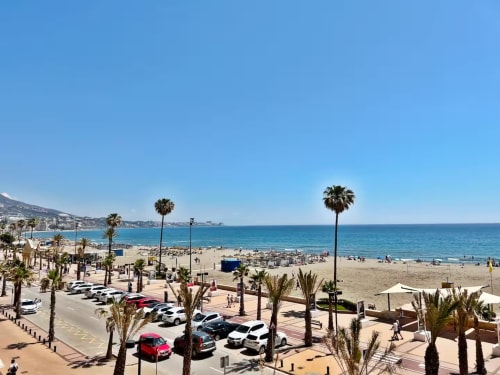 Vista del apartamento frente al mar en Fuengirola con el Mediterráneo, playa de arena, palmeras y cielo azul despejado