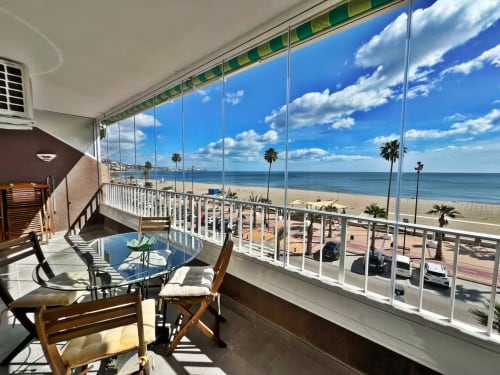Balcón de apartamento frente al mar en Fuengirola con vistas al mar, zona de comedor y palmeras