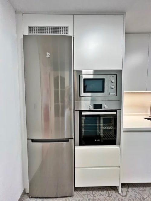 Cocina moderna con electrodomésticos de acero inoxidable, nevera, microondas y horno Bosch en apartamento frente al mar en Fuengirola
