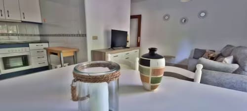 Acogedora zona de cocina-salón en Fuengirola con electrodomésticos modernos, mesa de comedor y sofá