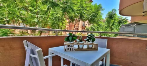 Terraza con comedor, plantas y vistas a la ciudad en apartamento de Fuengirola