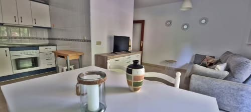 Apartamento moderno en Fuengirola con cocina abierta, comedor, salón con sofá gris y vistas a la ciudad