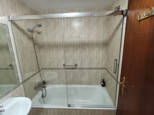 Cuarto de baño moderno con ducha de cristal y bañera en apartamento de playa en Fuengirola