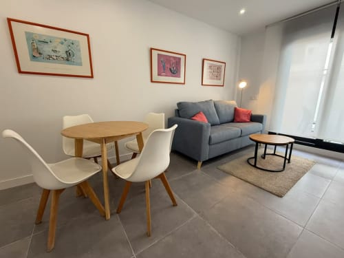 Moderno apartamento de playa en Fuengirola con mesa de comedor, sofá y cuadros decorativos