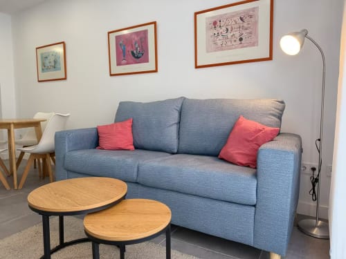 Moderno salón con sofá azul y cojines rojos en luminoso apartamento frente al mar, Fuengirola