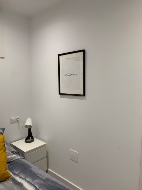 Detalle de dormitorio moderno con cuadro 'Wilderness' sobre lámpara de mesita en apartamento de Fuengirola