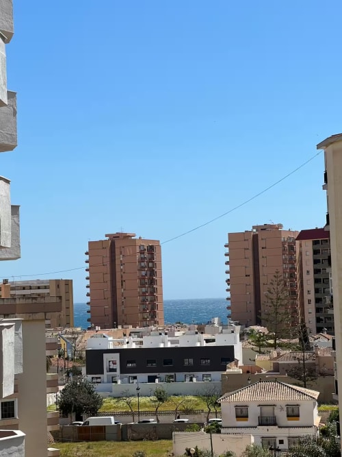 Edificio de apartamentos frente al mar en Fuengirola con vistas al mar, arquitectura moderna, zona de piscina compartida y costa mediterránea