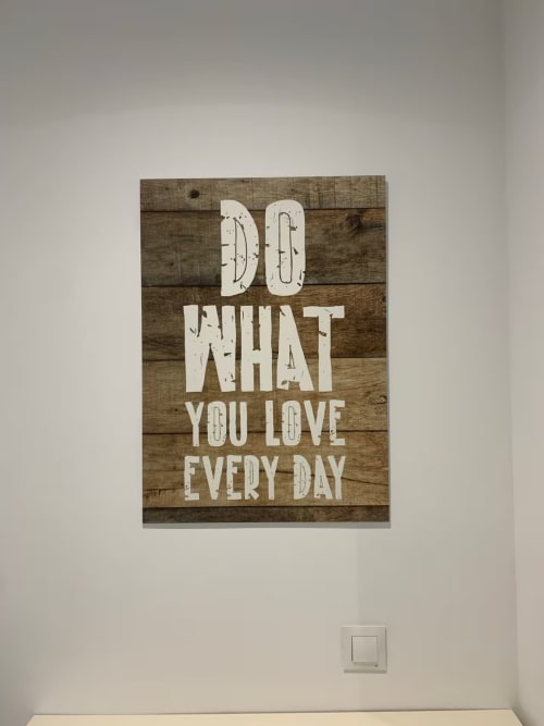 Letrero de madera en pared con texto blanco que dice 'Haz Lo Que Amas Cada Día' en apartamento de Fuengirola