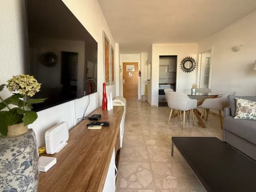 Moderno salón de apartamento en Fuengirola con zona de comedor, televisor de pantalla plana y decoración costera