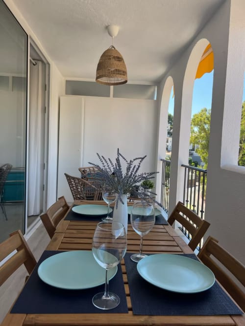 Elegante comedor en apartamento frente al mar con balcón con vistas, lámpara colgante de mimbre y mesa moderna en Fuengirola